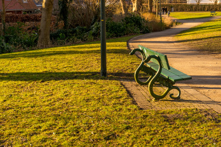 Belgium, Bruges, empty  bench on lush green fieldの写真素材