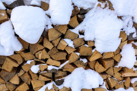 Snow log stack lumber in winter. Woodpile of pineの写真素材