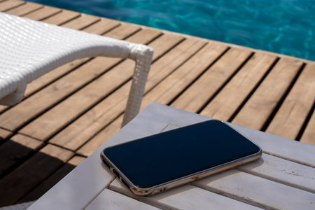 mobile phone standing on wooden floor by the beachの写真素材