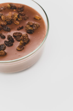 tasty cocoa and chocolate pudding with raisins on top in a bowl with space for textの写真素材