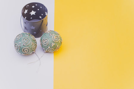 Green Christmas decorative balls with sapce for text on a white yellow paper surfaceの写真素材