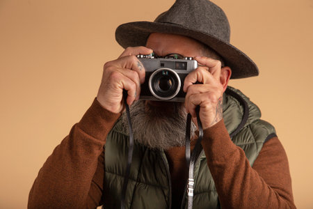 hipster tourist photographer isolated on light background holding vintage cameraの写真素材