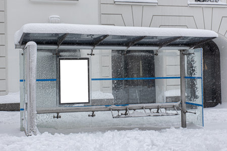 Bus stop on a snowy winter's day with blank advertisement signの写真素材