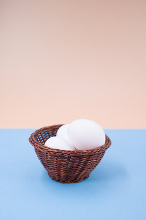 organic white eggs in a canister on a blue beige surface with copy space for textの写真素材
