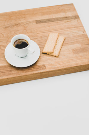 espresso coffee and biscuits on a wooden chopping board and white background with copy spaceの写真素材