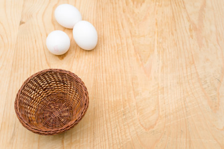 organic white eggs in a canister on a natural wooden tabletop surface with copy space for textの写真素材