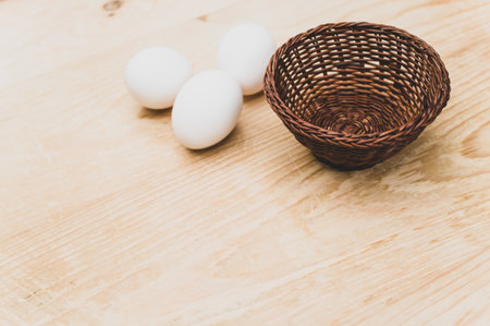 organic white eggs in a canister on a natural wooden tabletop surface with copy space for textの写真素材