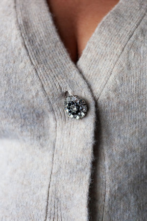 Detail Of brigth stones Button On cream Woolen Sweaterの写真素材