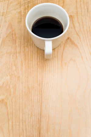 black coffee in a white mug on a rough wooden background with space for textの写真素材