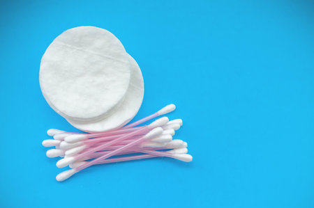 Cotton pads and cotton sticks on a blue background with a place for writing. The concept of body care.の写真素材