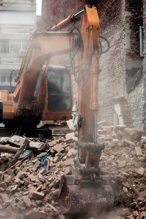 Excavator demolishing a brick house