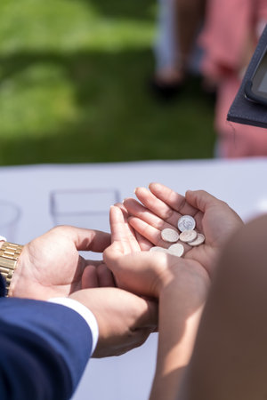 Hands of the groom and bride with the earnest in hand at the wedding celebrationの写真素材