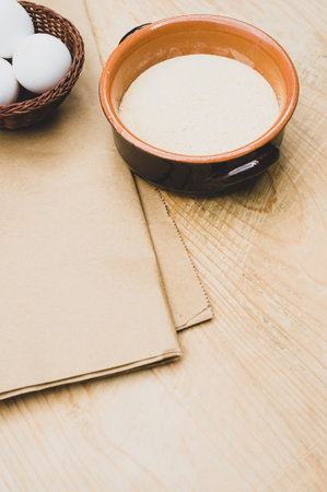 white eggs and terracotta bowl with wholegrain flour on rustic wooden background with copy spaceの写真素材