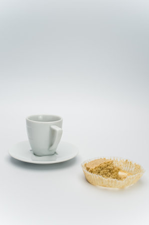 black hot ristretto coffe in a white stoneware cup with plate with nibbled pie on a white surface with text spaceの写真素材