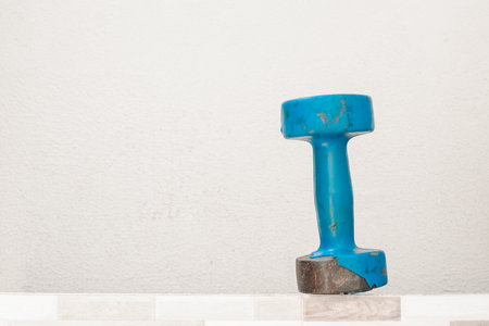 Second hand blue dumbbell, standing upright (used, rusty) white background, space for text. exercise and health concept. fitness conceptの写真素材
