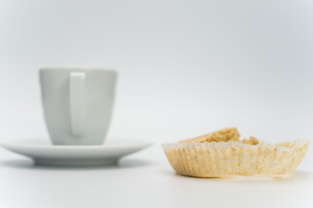 black hot ristretto coffe in a white stoneware cup with plate with nibbled pie on a white surface with text spaceの写真素材