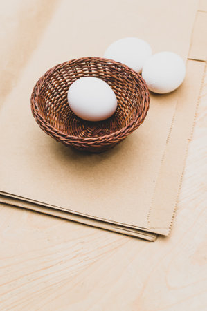 organic white eggs in a canister on a natural wooden and paper background with copy space for text