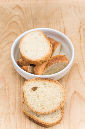 organic fresh sliced bread in a white bowl on a wooden tabletop with copy spaceの写真素材