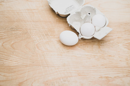 cardboard egg box made of recyclables materials with space for text on a wooden tabletopの写真素材