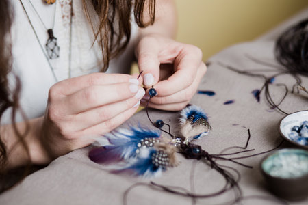 Woman making handmade gemstone jewelry, home workshop. Artisan woman creates jewelry. Art, hobby, handcraft conceptの写真素材