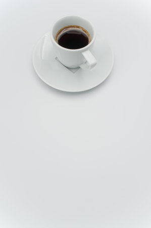 black hot ristretto coffe in a white stoneware cup with plate on a white surface with text spaceの写真素材