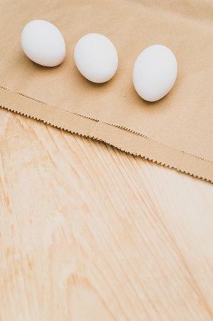 organic white eggs on a natural wooden and brown paper background with copy space for textの写真素材