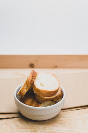 organic fresh sliced bread in a white bowl on a wooden tabletop with copy spaceの写真素材