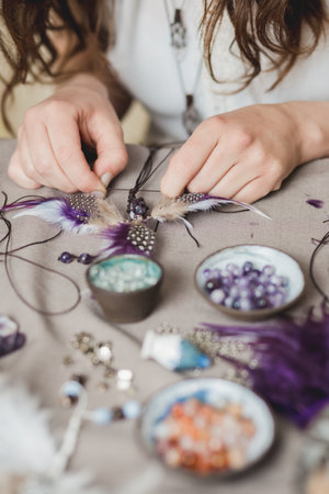 Woman making handmade gemstone jewelry, home workshop. Woman artisan creates jewelry. Art, hobby, handcraft conceptの写真素材