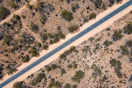 Aerial view of a long straight road in the middle of pink sand in the Australian outback in South Australiaの写真素材