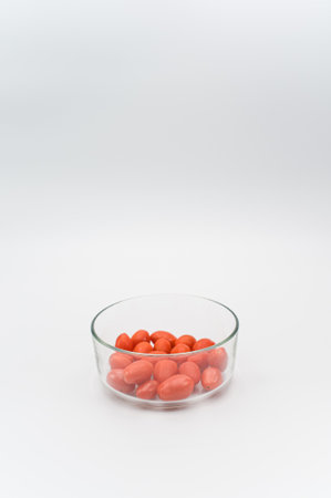 natural organic ripe datterini tomatoes in a glass bowl on a white background with text spaceの写真素材