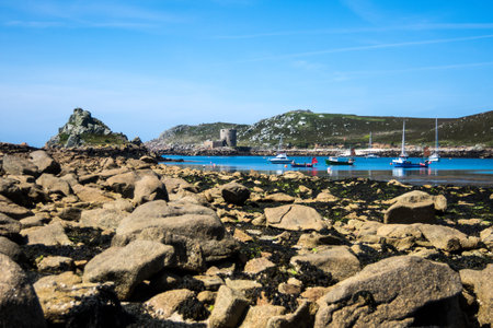 Boats lie at anchor near Cromwells Castle, Tresco, Scilly Isles.の写真素材