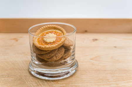 organic sweet biscuits and pastries in a glass jar on a rustic wooden tabletop with text spaceの写真素材