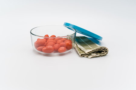 natural organic ripe datterini tomatoes in a glass bowl on a white background with text spaceの写真素材