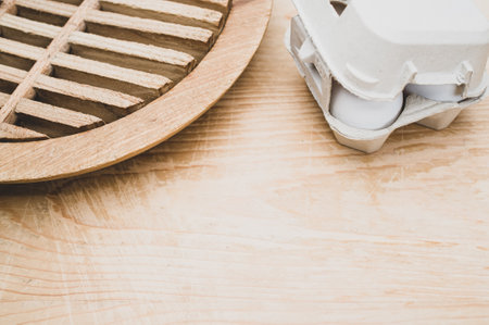 cardboard egg box made of recyclables materials with space for text on a wooden tabletopの写真素材