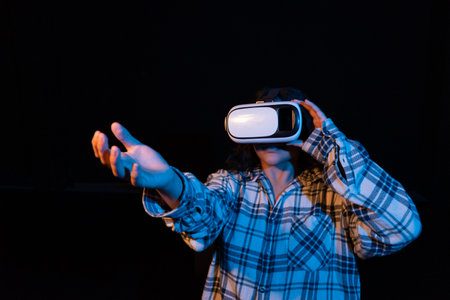 Young woman wearing virtual reality glasses for the first time. Experiencing the environment of...
