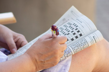 woman with no visible face completing a crosswordの写真素材