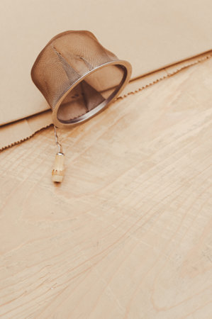 metal tea strainer on a kraft paper and wooden background with text spaceの写真素材