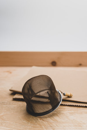 metal tea strainer on a kraft paper and wooden background with text spaceの写真素材