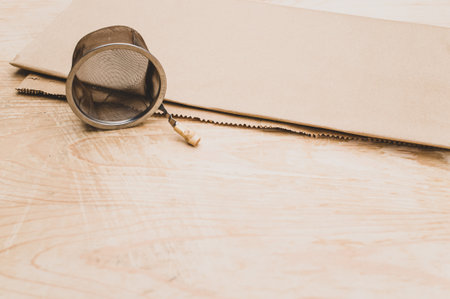 metal tea strainer on a kraft paper and wooden background with text spaceの写真素材