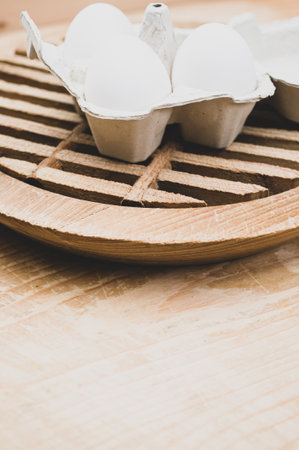 cardboard egg box made of recyclables materials with space for text on a wooden tabletopの写真素材