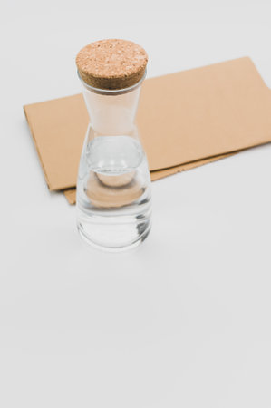 glass flask filled with pure clean water on a white and food paper background with text spaceの写真素材