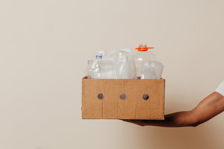 Hand holding box with trash over background.の写真素材