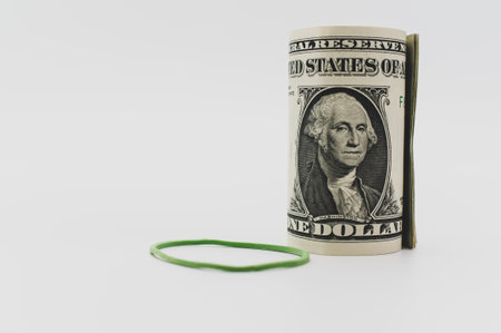 US dollar banknotes rolled up on a white tabletop with text spaceの写真素材