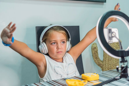 Caucasian girl with headphones and open arms while recording a video. Concept new technologies.