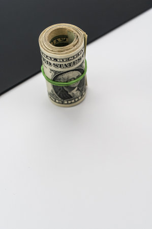 rolled up US dollar banknotes on  black white background with text space