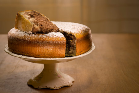 vanilla and chocolate cake (marble cake) on old base and wooden table with a cut piece