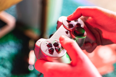Holding a retro gaming controller in the neon lightの写真素材