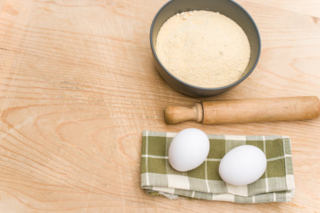 kitchen tools white eggs and dark gray bowl with wholegrain flour on worn wooden background with...
