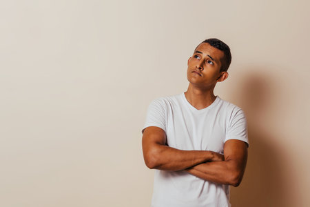 Young latin american man thinking looking away.の写真素材