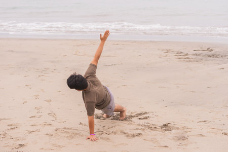 Young man practicing various poses in yoga on the beach. Enjoying a great day and sun.
